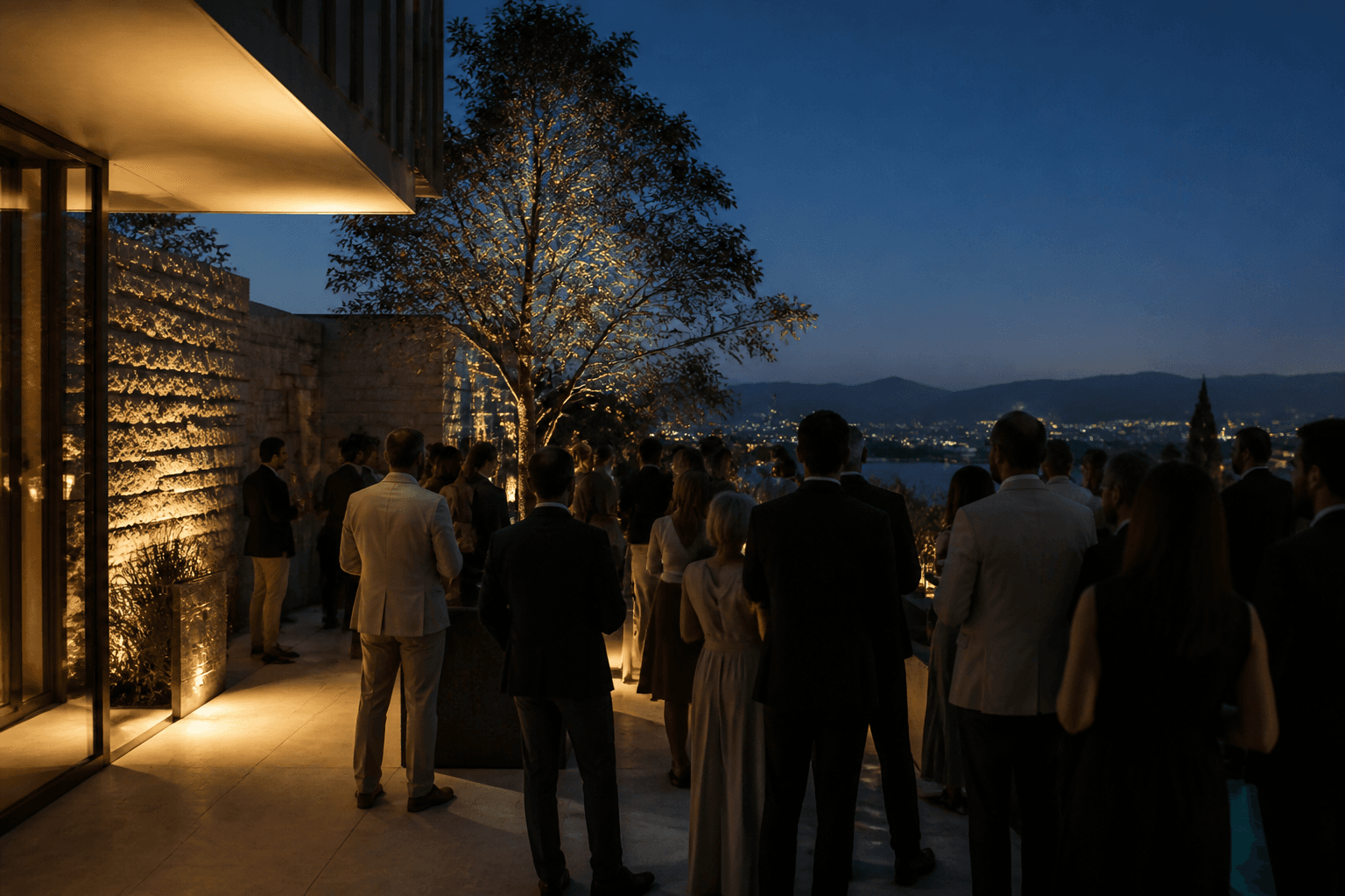 A hosted evening on an architectural terrace, guests gathered in conversation.